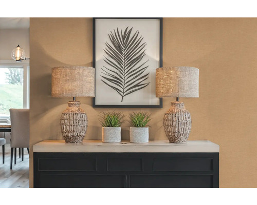 Dekorativní scéna se dvěma lampami, rostlinami a zarámovaným obrázkem listu na skříňce