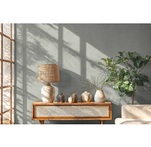 Obývací pokoj se stolní lampou, dekorací a rostlinou na dřevěné skříňce.