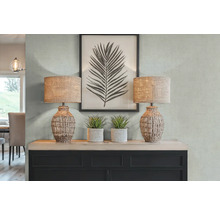 Dekorativní interiér se dvěma stolními lampami, umělými rostlinami a zarámovaným potiskem listů na komodě.