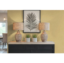 Dekorativní interiér se dvěma stolními lampami, rostlinami a zarámovaným potiskem listů na příborníku