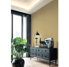 Obývací pokoj s černou komodou, lampou, dekorací a pokojovou rostlinou