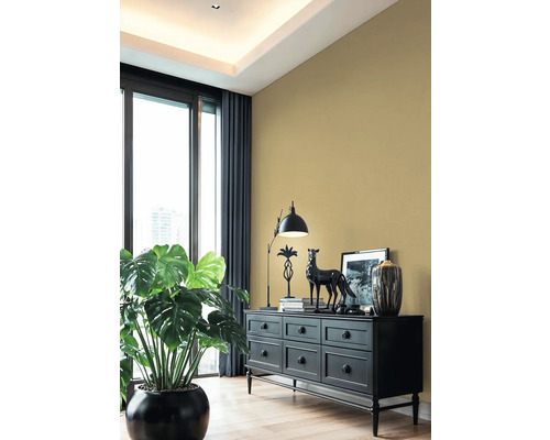 Obývací pokoj s černou komodou, lampou, dekorací a pokojovou rostlinou