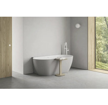 Světlá koupelna s volně stojící vanou, armaturou a dřevěnými prvky pro moderní atmosféru.