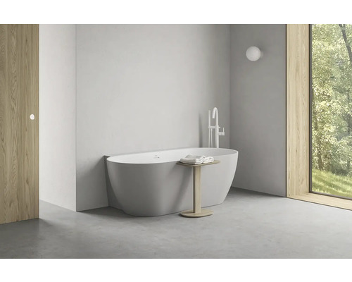 Světlá koupelna s volně stojící vanou, armaturou a dřevěnými prvky pro moderní atmosféru.