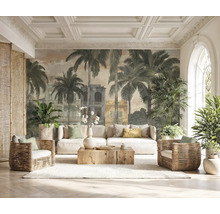 Fototapeta s palmami a koloniálními budovami ve světlém obývacím pokoji s bílou pohovkou, proutěnými křesly a dřevěným konferenčním stolkem.