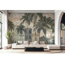 Světlý obývací pokoj s fototapetou ve vintage stylu s palmami a koloniálními budovami. Bílá rohová pohovka, černý konferenční stolek a koberec.