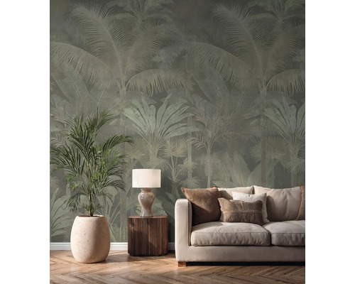 Vliesová tapeta s motivem palem ve světlém obývacím pokoji za krémovou pohovkou, stolní lampou a velkou pokojovou rostlinou.