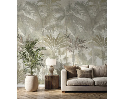 Vliesová tapeta s velkým vzorem palem ve světlém obývacím pokoji s béžovou pohovkou, dřevěným nábytkem a pokojovou rostlinou.