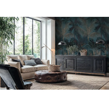 Obývací pokoj s fototapetou s motivem palem v tmavě modré a zlaté barvě, světlou pohovkou, koženým taburetem a černou komodou u velkých oken.