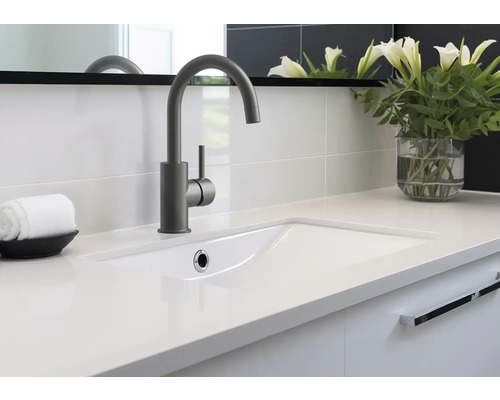 Koupelnové umyvadlo s baterií, ručníkem a vázou s květinami