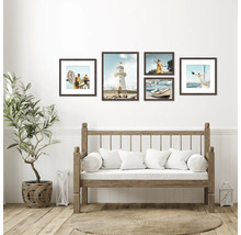 Dekorativní rámy s pobřežními motivy nad lavicí s polštáři