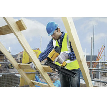 Stavební dělník používá pásovou hřebíkovačku Bostitch na staveništi.