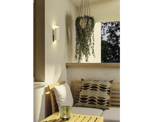 Scéna s nástěnnou lampou, závěsnou rostlinou a posezením venku