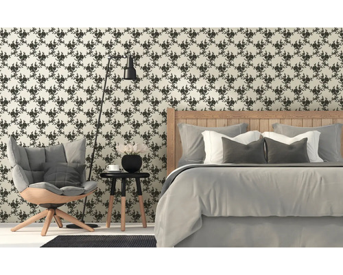 Ložnice s květinovou tapetou, postelí, křeslem a stojací lampou