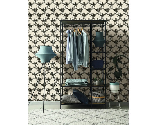 Ukázka uspořádání s věšákem na oblečení, stojací lampou a vzorovanou tapetou pro stylové prostředí.