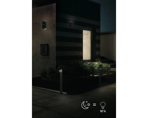 Venkovní pohled na dům s zahradním osvětlením a nástěnnými svítidly v noci