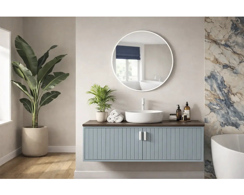 Světlá koupelna s umyvadlovou skříňkou, kulatým zrcadlem a pokojovými rostlinami.