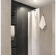 Moderní koupelna se sprchovým závěsem, topným žebříkem a ručníkem