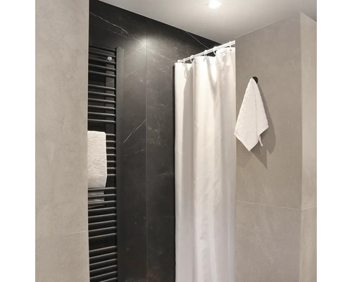 Moderní koupelna se sprchovým závěsem, topným žebříkem a ručníkem