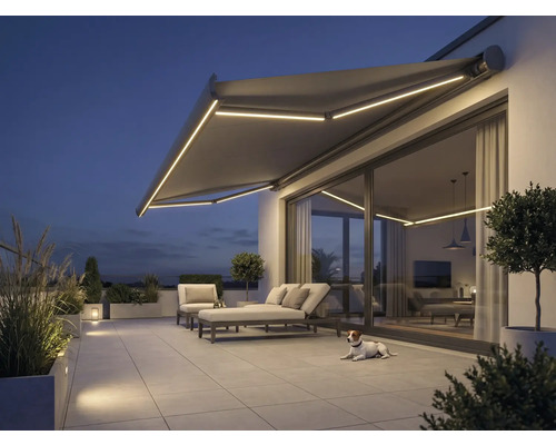 Terasa s markýzou, zahradním nábytkem a osvětlením ve večerních hodinách