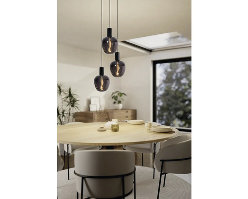 Tři závěsná svítidla s dekorativními žárovkami nad jídelním stolem