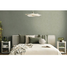 Moderní ložnice s texturovanou šalvějově zelenou tapetou, bílou postelí s polštáři, závěsným svítidlem ve tvaru květu a nočními stolky.