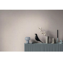 Moderní dekorace interiéru s figurkou ptáčka, mramorovou vázou s bavlníkovou větví a svícny na drážkovaném povrchu.