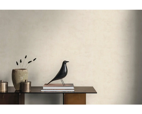 Světlá stěna se strukturovanou tapetou v minimalistické místnosti s komodou, dekorativní figurkou ptáka a kamennou vázou.