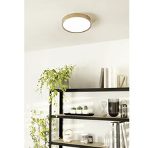 Stropní svítidlo s dřevěným okrajem ve světlé místnosti nad policí.