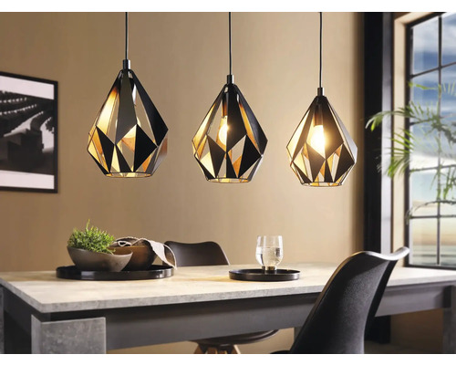 Tři geometrická kovová závěsná svítidla nad jídelním stolem