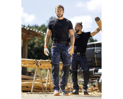Dva muži mají na sobě pracovní kalhoty s maskovacím vzorem, trička a pracovní rukavice.