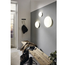 Světlý vstupní prostor s dřevěnou stoličkou, nástěnnými svítidly a věšákem