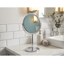 Volně stojící kulaté kosmetické zrcadlo z kovu v koupelně