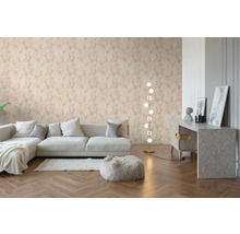 Obývací pokoj s květinovou tapetou se vzorem růží, světlá pohovka, dřevěná podlaha s rybinovým vzorem a moderní stojací lampa.