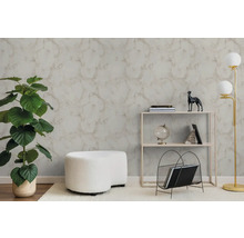 Moderní obývací pokoj s texturovanou tapetou se vzhledem mramoru, velkou zelenou rostlinou, bílým taburetem a minimalistickým regálem.