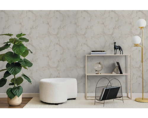 Moderní obývací pokoj s texturovanou tapetou se vzhledem mramoru, velkou zelenou rostlinou, bílým taburetem a minimalistickým regálem.