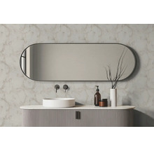 Oválné koupelnové zrcadlo nad bílým umyvadlem na desku a drážkovanou skříňkou před stěnou s mramorovým dekorem.