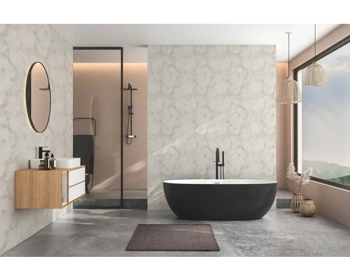 Moderní koupelna s volně stojící černou vanou, závěsnou dřevěnou skříňkou, kulatým zrcadlem, sprchou, mramorovanými stěnami a podlahou ve vzhledu betonu.