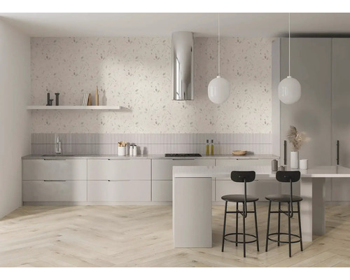Světlá moderní kuchyně s květinovou tapetou, světlou dřevěnou podlahou rybí kost, bílými skříňkami, ostrůvkem, černými barovými stoličkami a svítidly.
