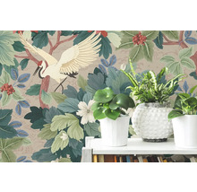 Vliesová tapeta s japonským motivem jeřába, velkými zelenými listy a červenými bobulemi za pokojovými rostlinami na bílé polici.