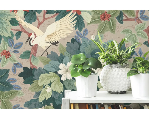 Vliesová tapeta s japonským motivem jeřába, velkými zelenými listy a červenými bobulemi za pokojovými rostlinami na bílé polici.