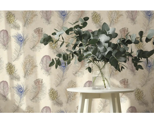 Vliesová tapeta se vzorem pavích per, před ní odkládací stolek s eukalyptovými větvemi ve skleněné váze.