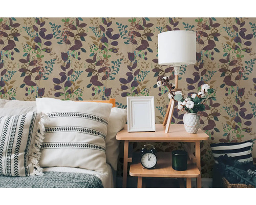 Vliesová tapeta s rostlinným motivem listů v ložnici se světlým dřevěným nočním stolkem a polštáři.