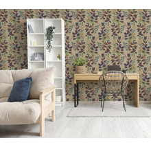 Obývací pokoj s botanickou tapetou s motivem listů, bílým regálem, dřevěným psacím stolem s ratanovou židlí a světlou pohovkou.