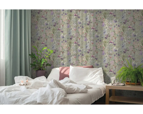 Ložnice s vliesovou tapetou s květinovým vzorem, bílou postelí s kočkou, pokojovými rostlinami a světlým závěsem.