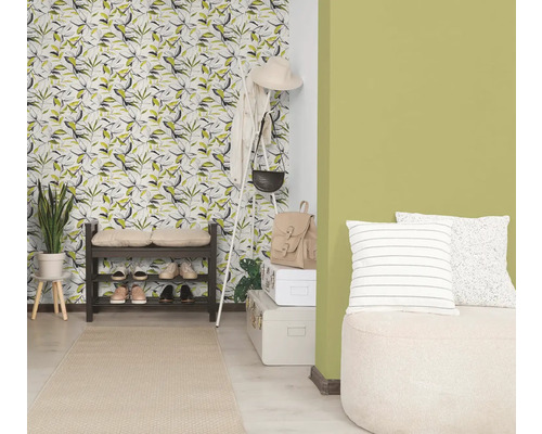 Svetlá předsíň s tapetou s motivem listů, zelenou barvou stěny, tmavým botníkem, bílým věšákem a světlým běhounem.
