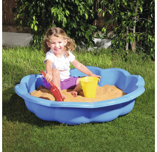 Dítě si hraje na zahradě v modrém pískovišti s hračkami do písku