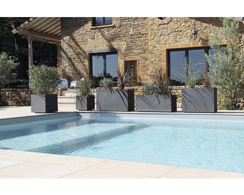 Řada květináčů různých velikostí vedle bazénu v zahradě.