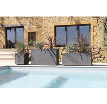 Tři šedé květináče různých velikostí u bazénu