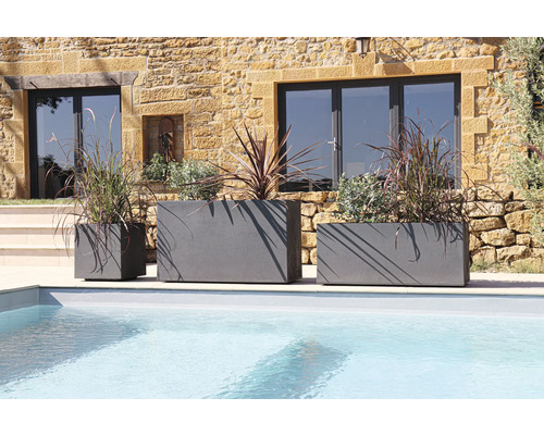 Tři šedé květináče různých velikostí u bazénu